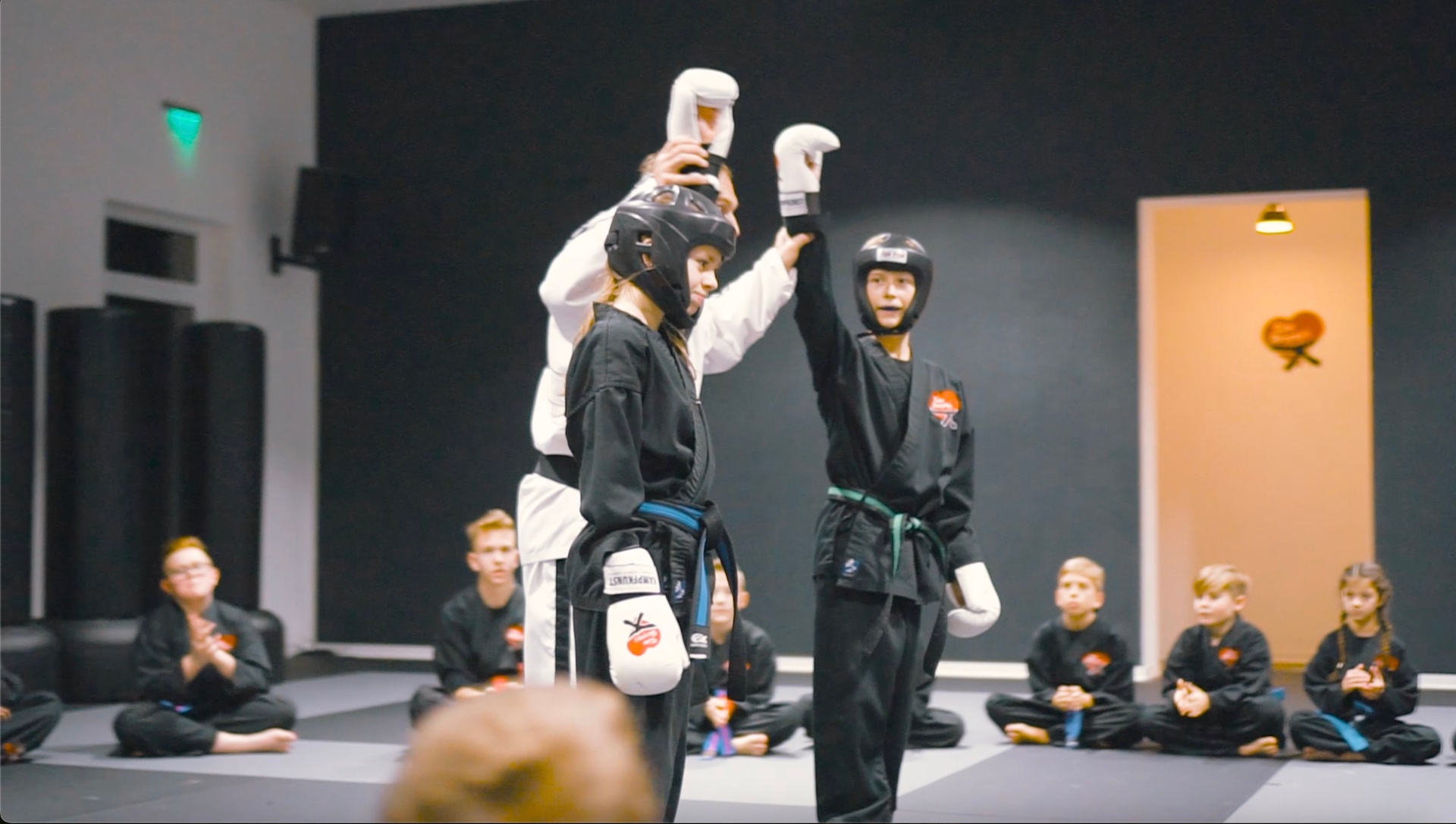 Lehrer und Kind beim High-Five im Dojo